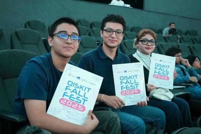 Students in an auditorium holding Qiskit Fall Fest flyers.