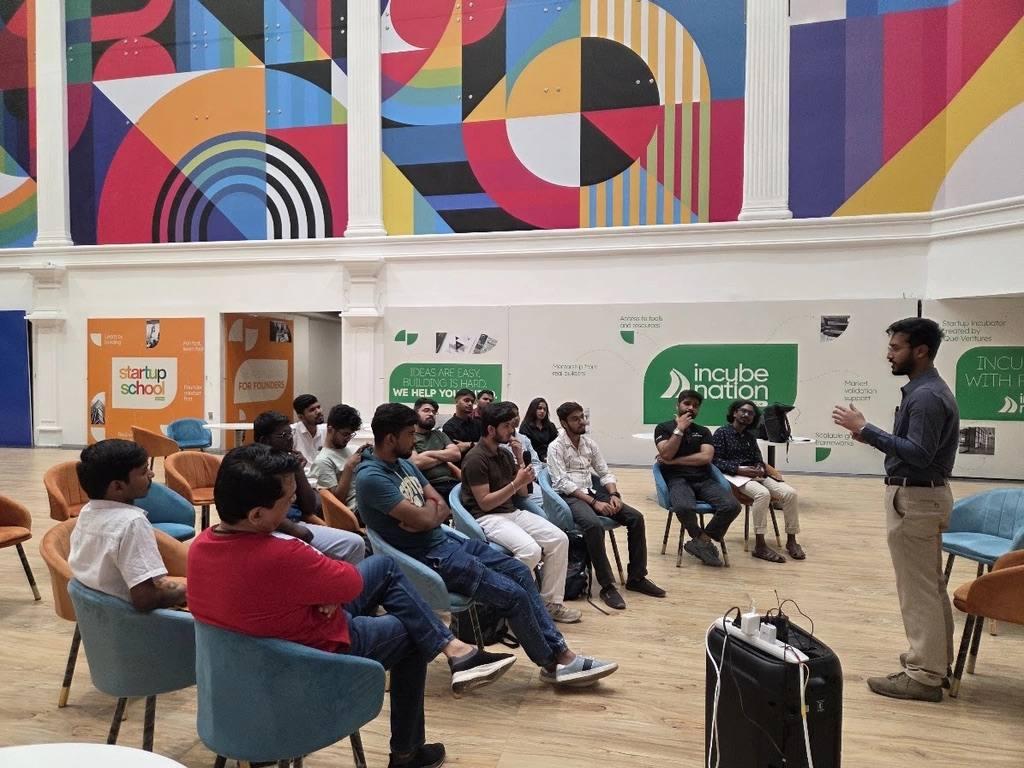 Speaker addressing a seated circle of participants at a community meetup