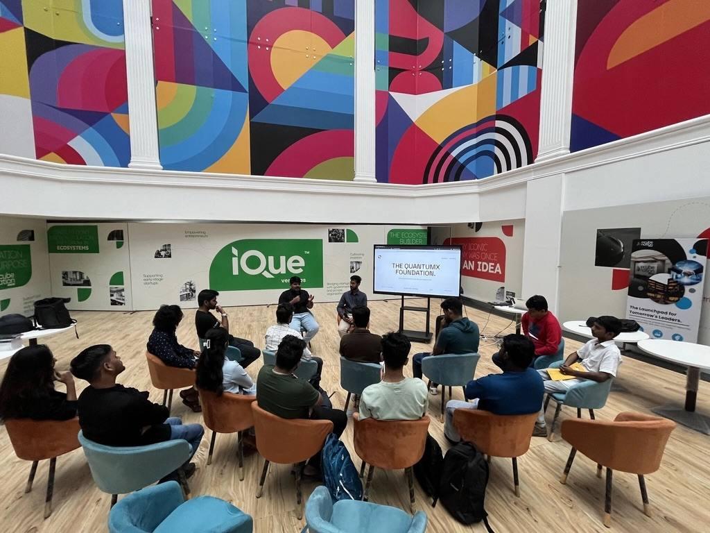 Small-group quantum workshop session beneath a painted mural