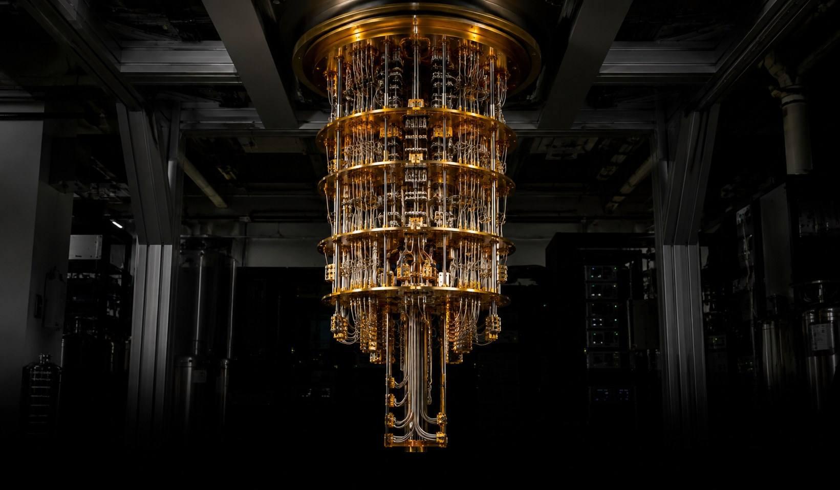 Gold-plated dilution refrigerator suspended in a darkened laboratory.