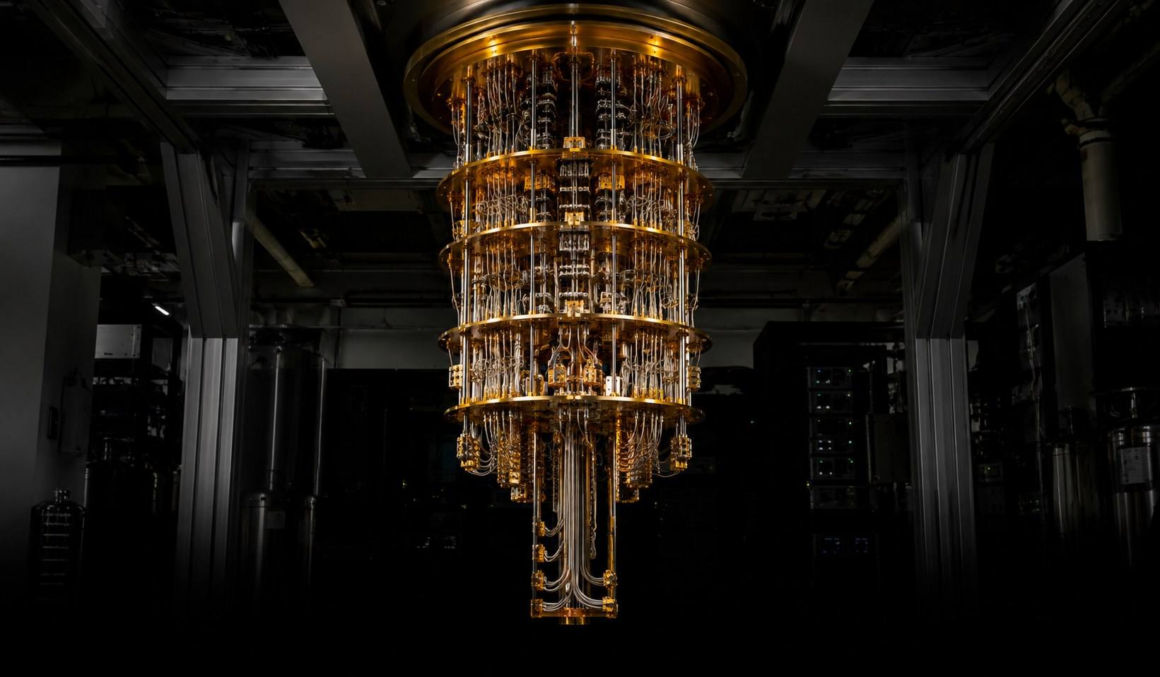 Gold-plated dilution refrigerator suspended in a darkened laboratory.